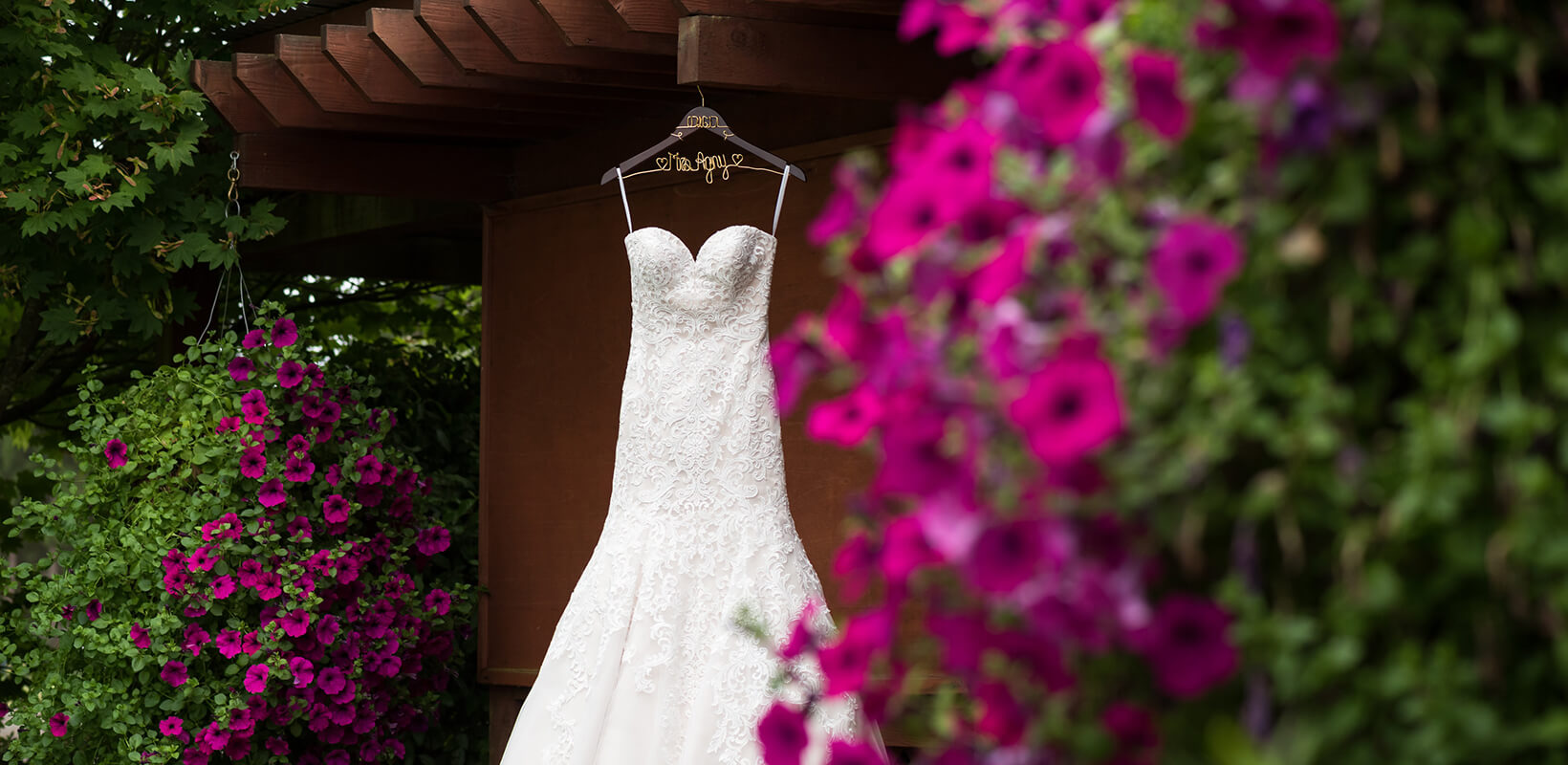 wedding dress hung by flowering plants